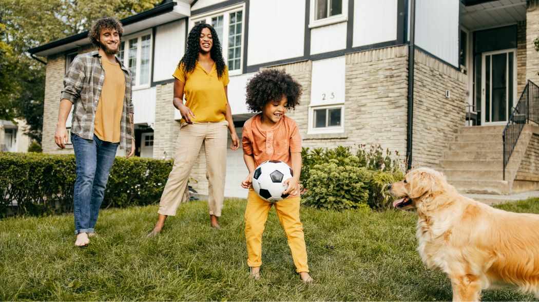 A family playing soccer with their dog