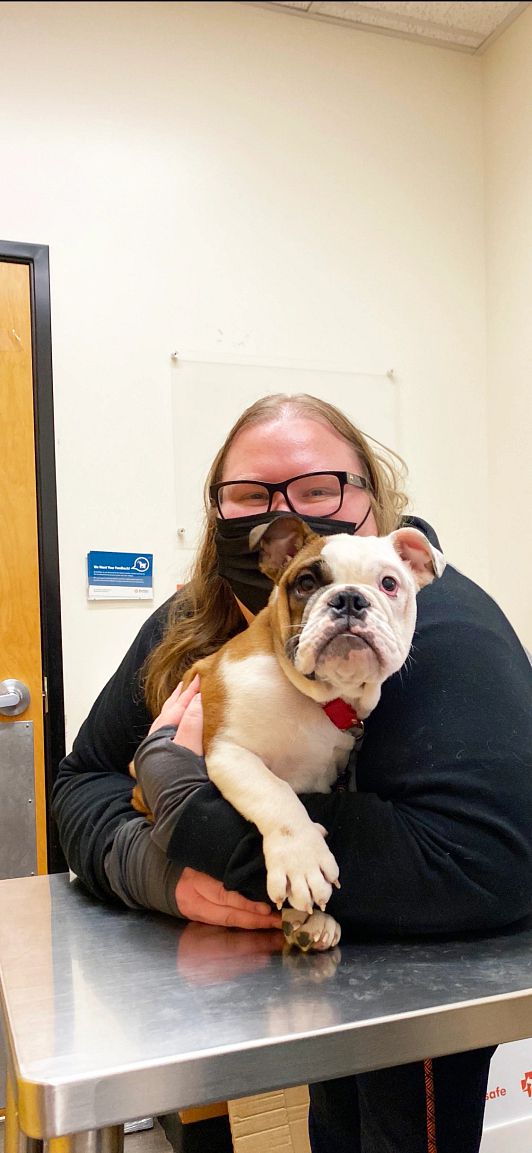 A young dog owner holding her dog